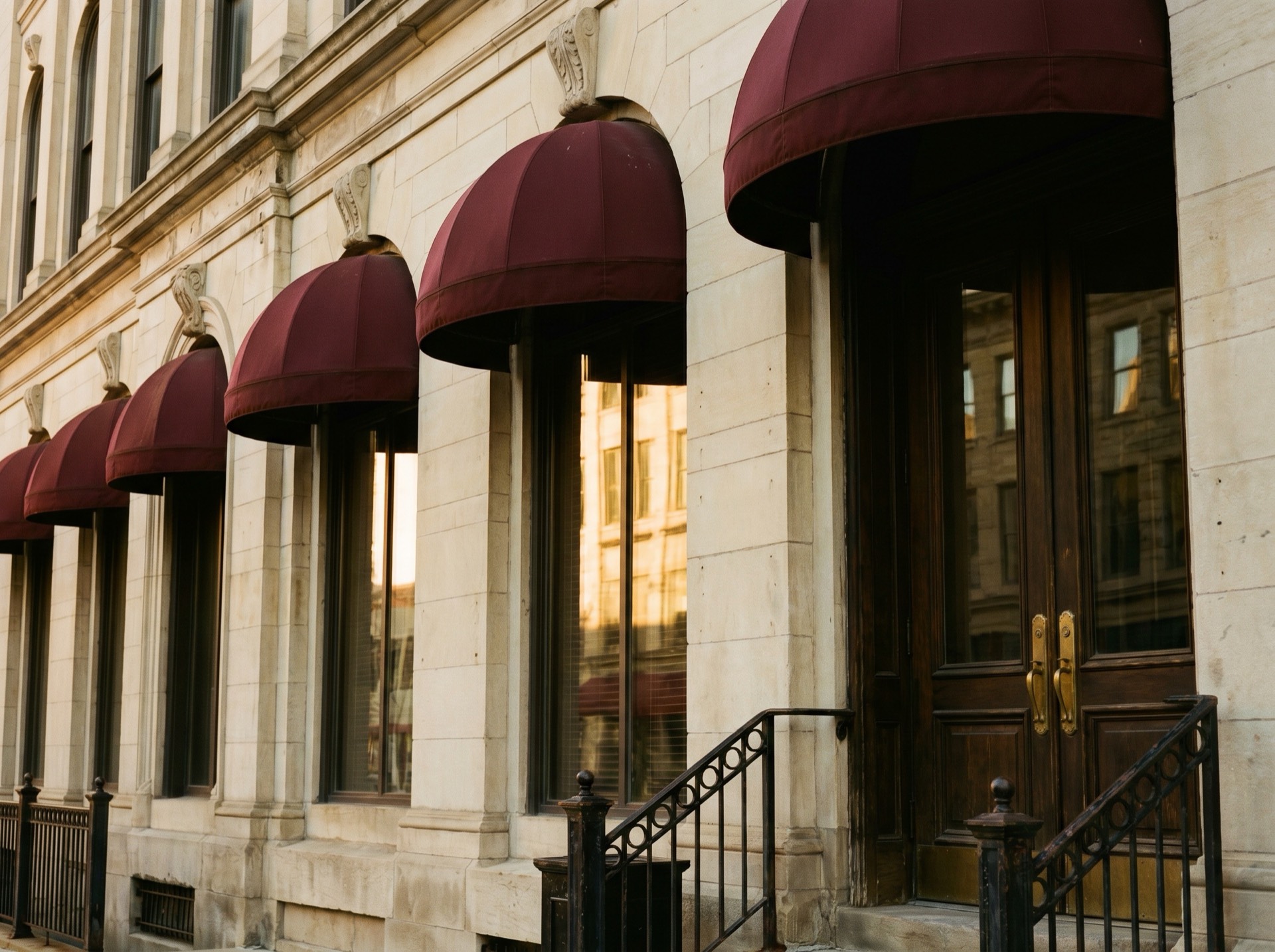 The limestone exterior of the firm's Milwaukee office with deep red awnings and tall windows.