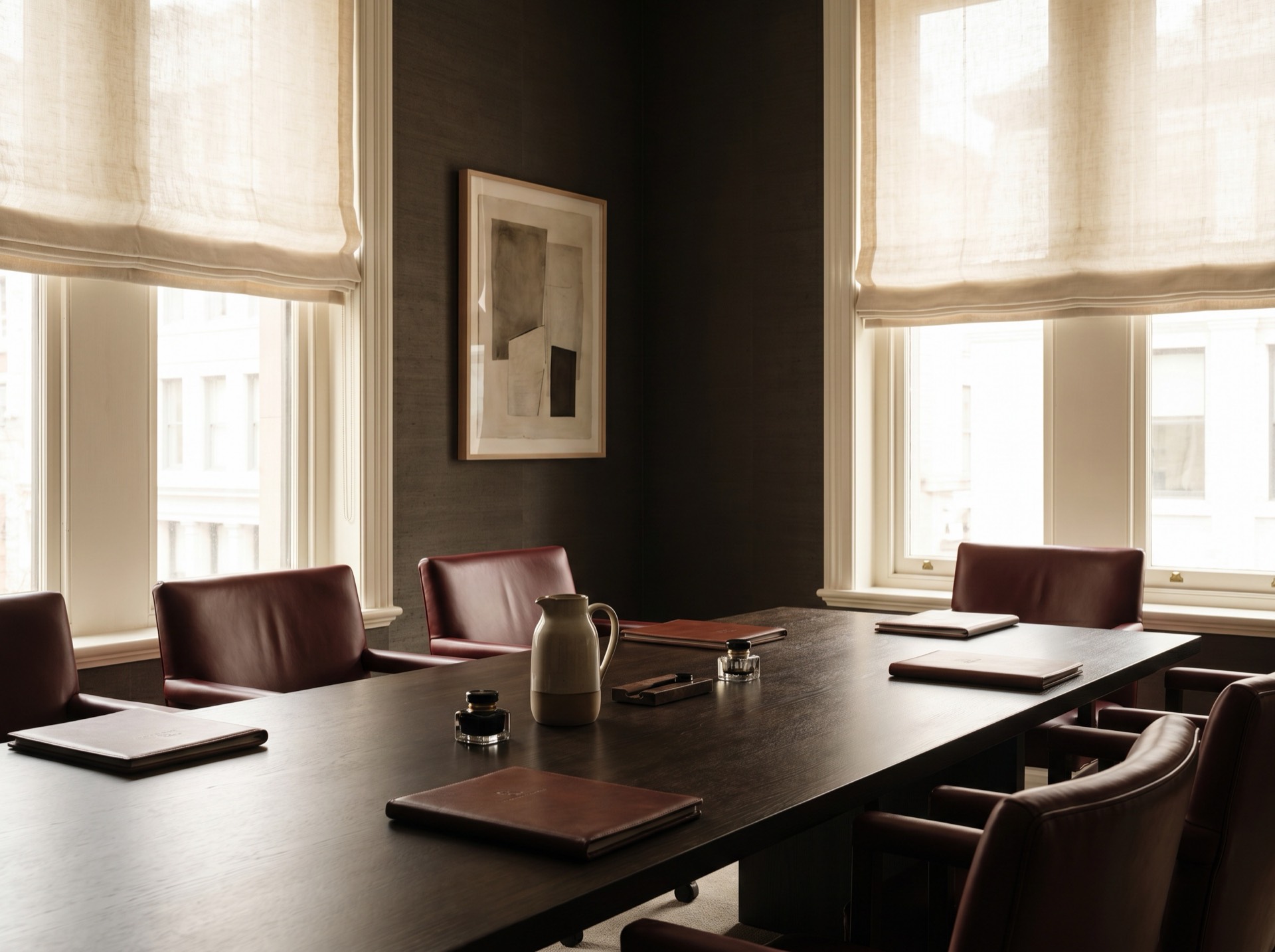 The firm's conference room, with a long wood table under clear window light.