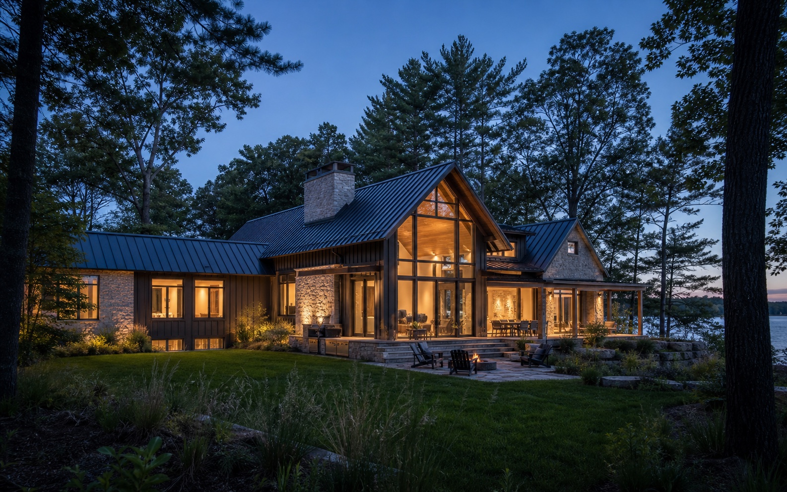 The Lantern House glowing through mature pines beside the lake at blue hour